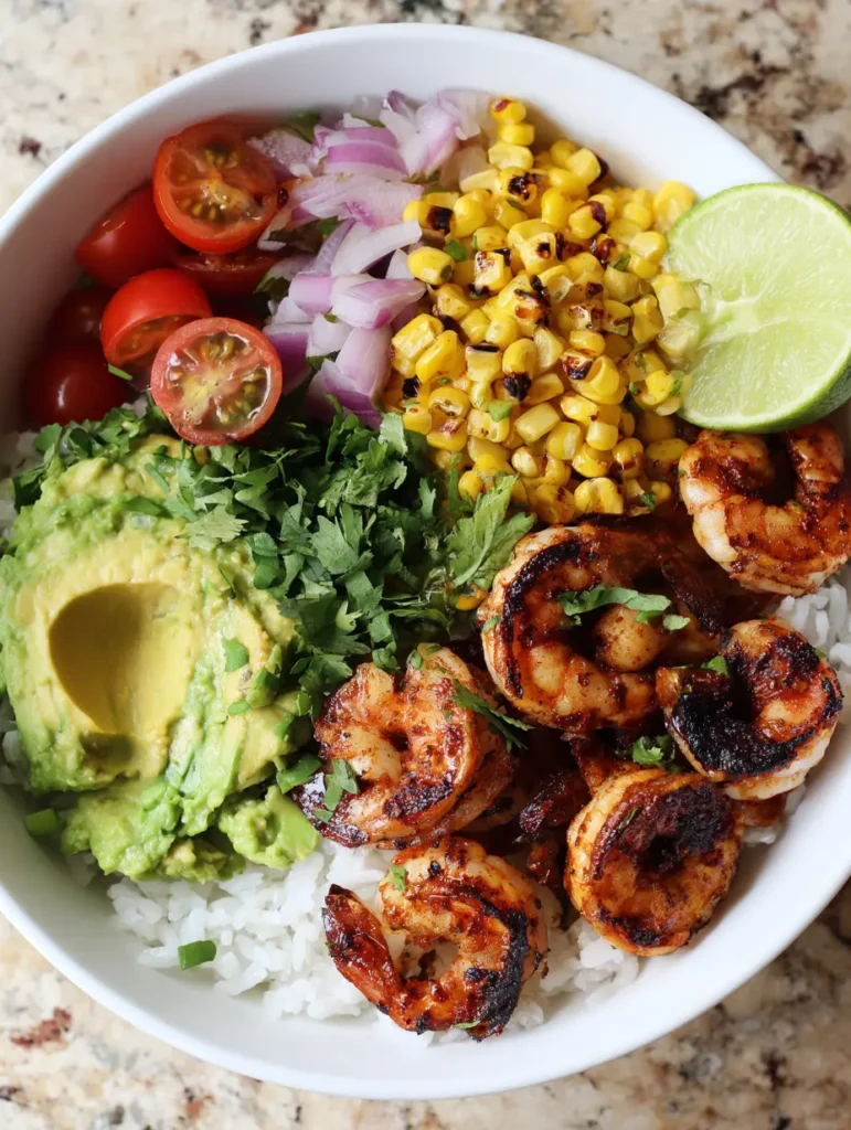 Grilled Shrimp Bowl with Charred Corn and Zesty Avocado 2 Top-down view of a Grilled Shrimp Bowl showing pink shrimp with char marks and bright green avocado.