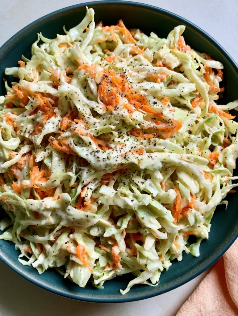 Close up of the velvety white dressing and black pepper specks on Homemade Coleslaw.