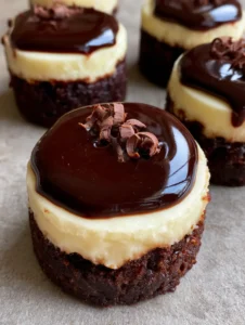 Bite-sized Brownie Bottom Mini Cheesecakes arranged on a neutral grey stone surface with natural daylight.